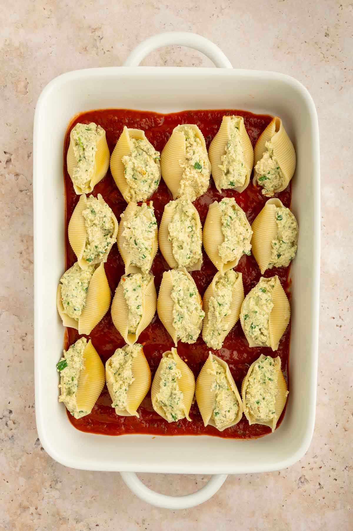 Plant-based pasta shells lined up in a casserole dish.