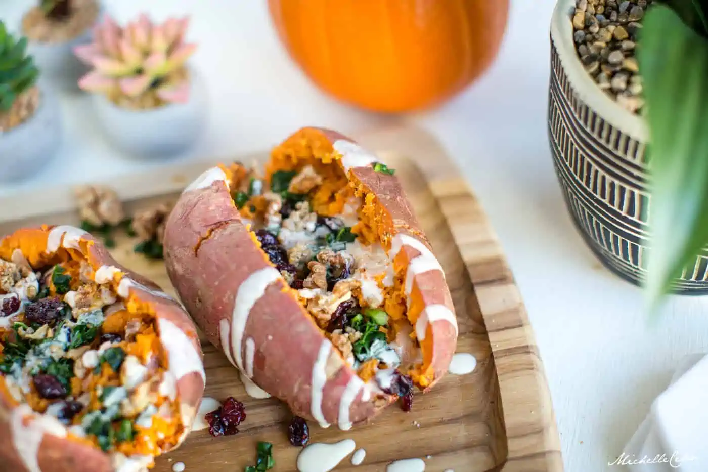 Stuffed sweet potatoes drizzled with a creamy tahini dressing.