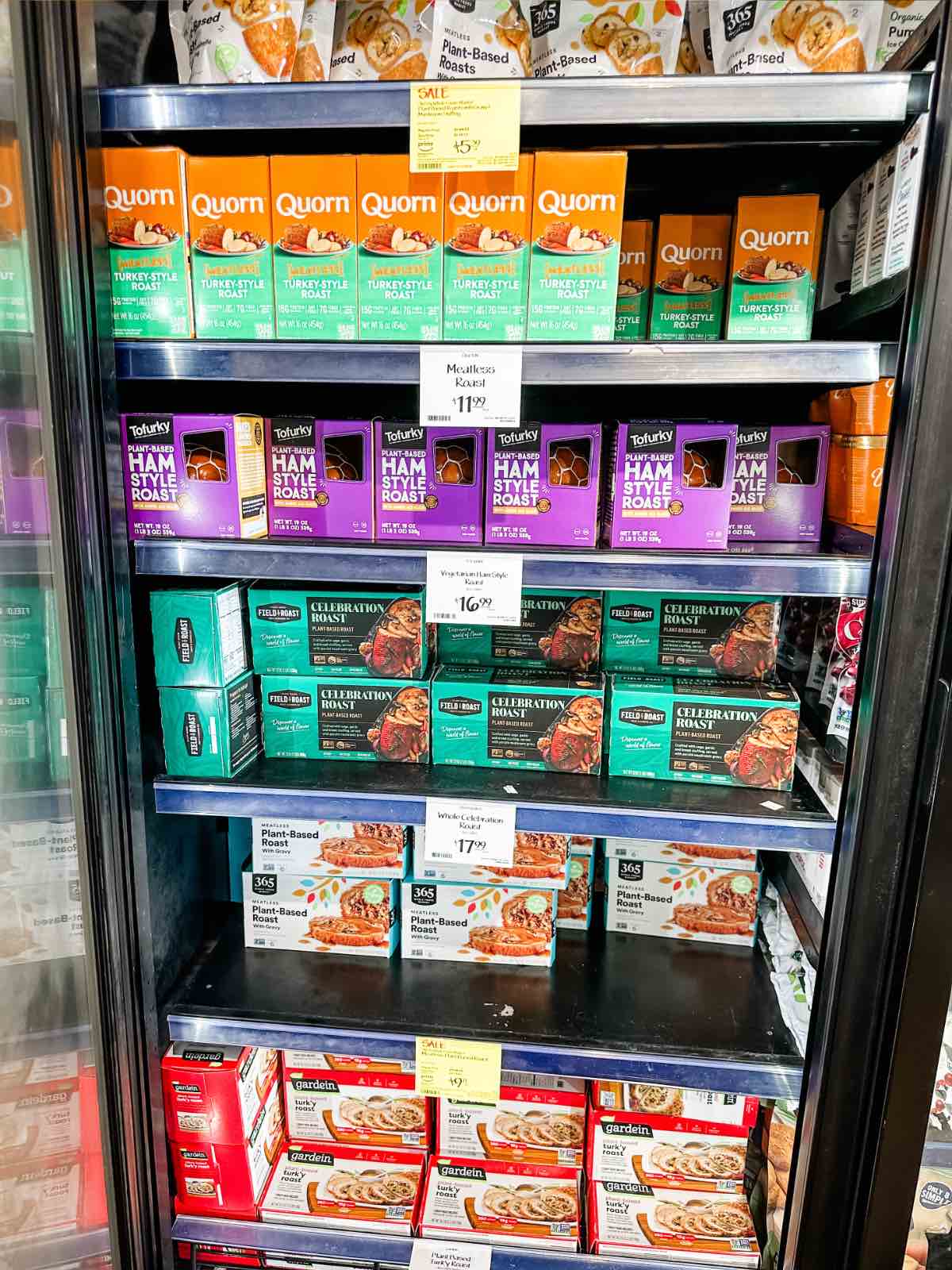An entire freezer case with several brands of plant-based vegan turkey options at Whole Foods grocery store.