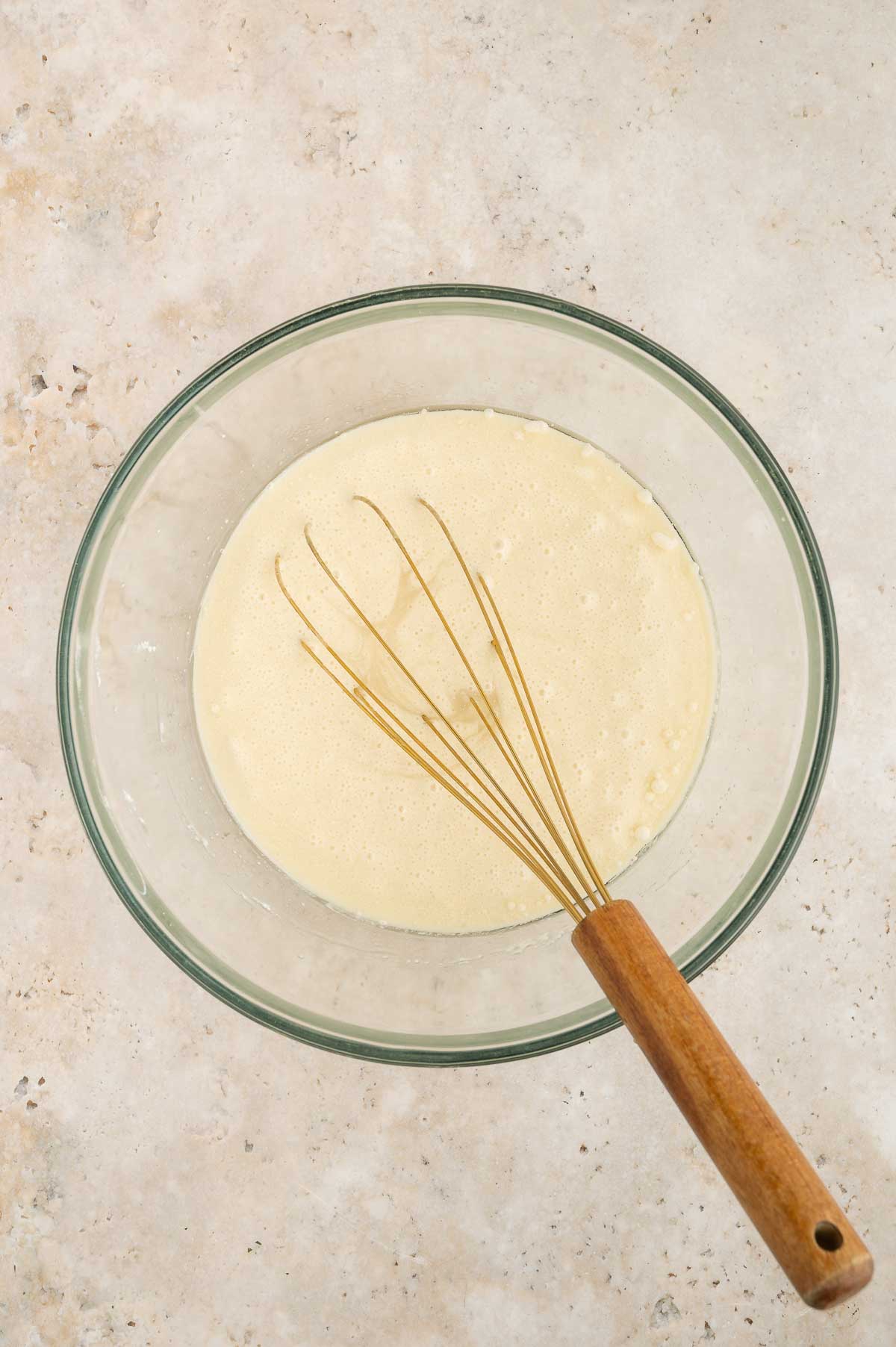 The wet ingredients for this vegan vanilla cake recipe in a large mixing bowl, whisked together.