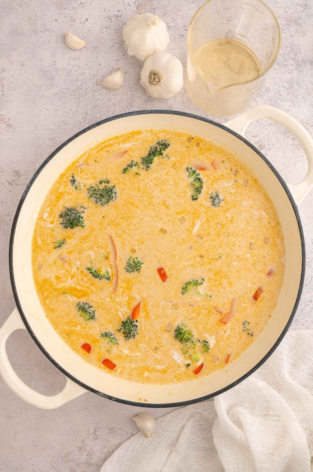 Thai-style soup in progress with coconut milk, vegetables, and yellow curry paste simmering.